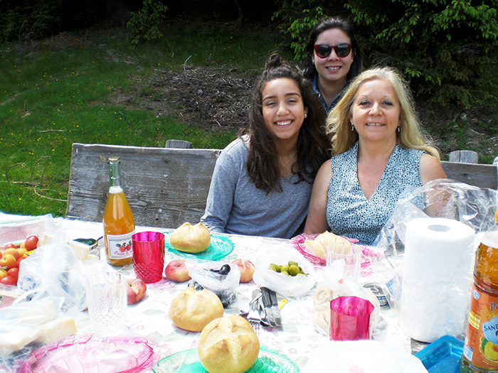 Mary Ann McCoy and another teacher and TESOL graduate, Nicole Bezerra, with her daughter Lilia enjoy lunch in the Italian Alps.