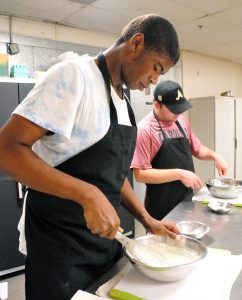 two students from the Academy for Inclusive Learning and Social Growth prepare crepes in the Culinary kitchen at KSU