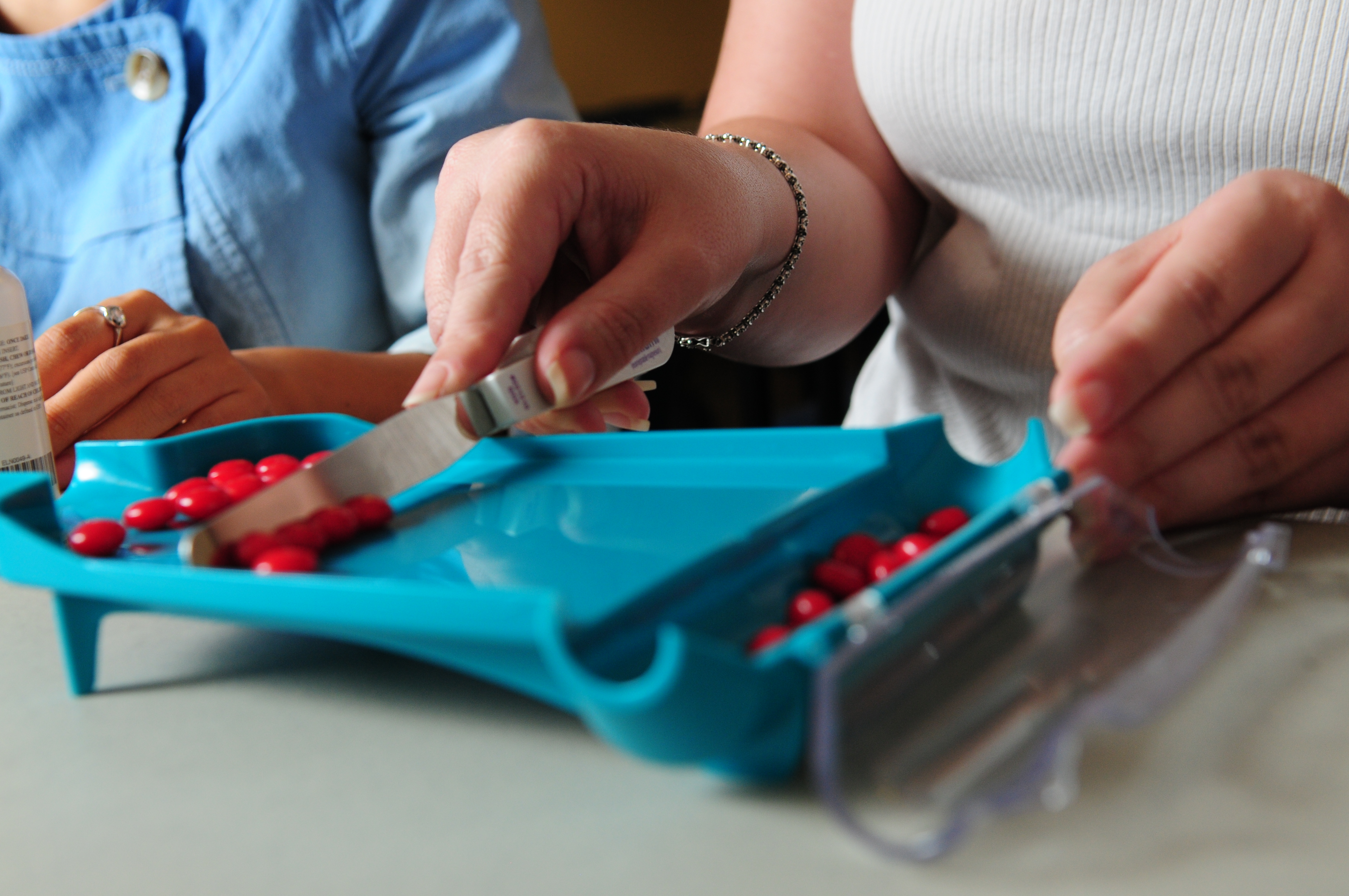 Student using a counting tray and spatula to count medication