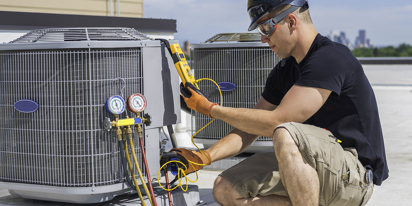 HVAC/R technician servicing a rooftop condensing unit
